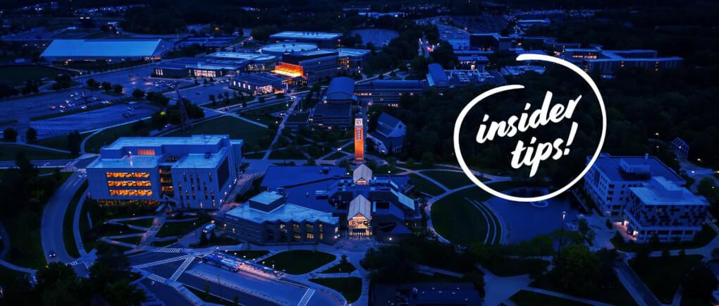 Aerial View of campus at night time with the Carillon tower lit up in the center